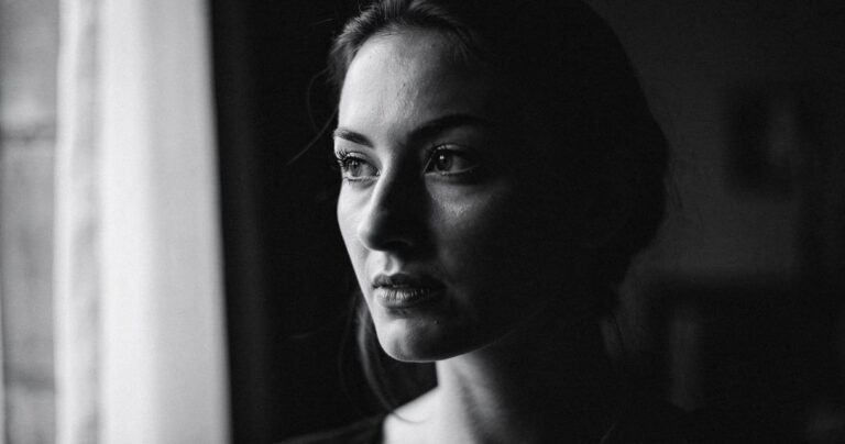 Portrait noir et blanc d une femme pres d une fenetre avec lumiere laterale